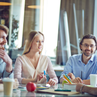 Vier Leute sitzen gemeinsam an einem Tisch und lernen